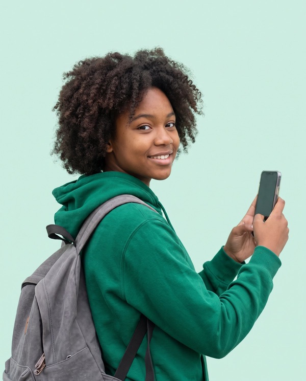 Teenage student in a green hoodie holding up a phone.